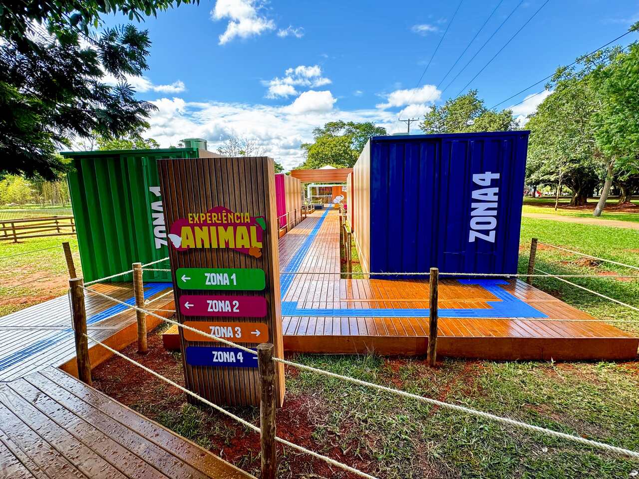 Visitantes percorrem exposição imersiva no Zoológico de Brasília, com painéis interativos, projeções e cenários inspirados na vida selvagem.